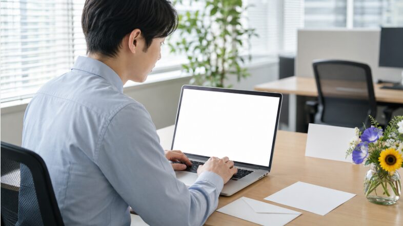 オフィスで7月の時候の挨拶をメールに書く日本人男性のビジネスシーン